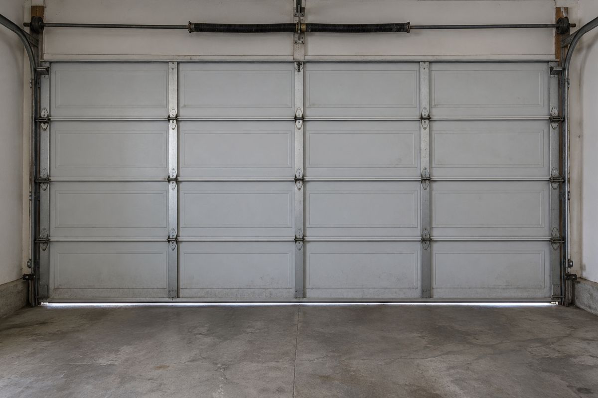 Inside of a closed garage door showing panel backs, struts, hinges and rollers in the tracks