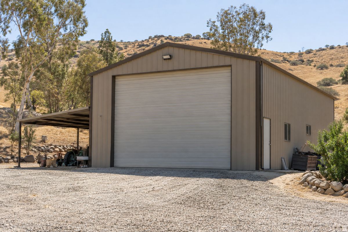Tall RV-height garage door on a detached workshop building on a rural property