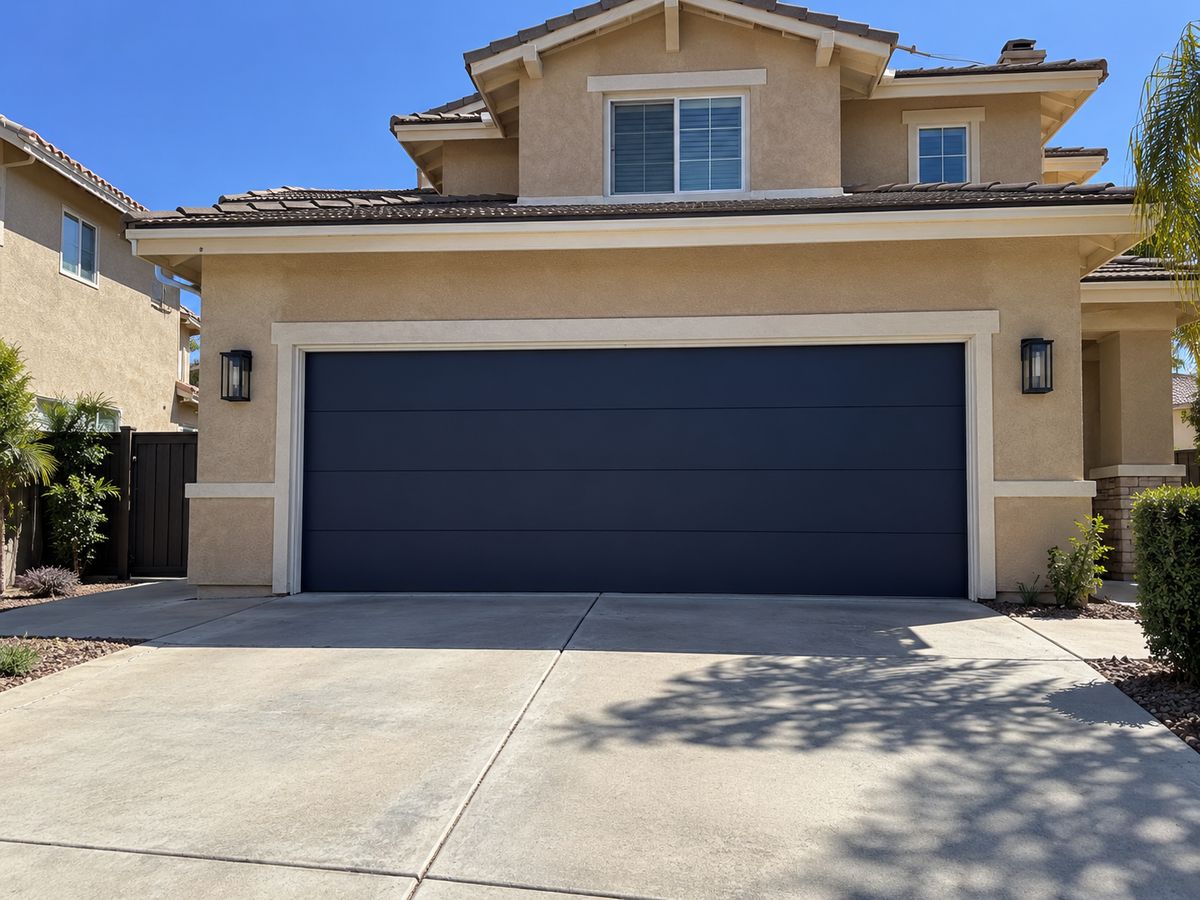 Dark navy flush garage door without windows on a two-story stucco home