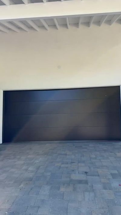 Before and after of a garage door replacement with a dark modern flush door on a white Los Angeles home