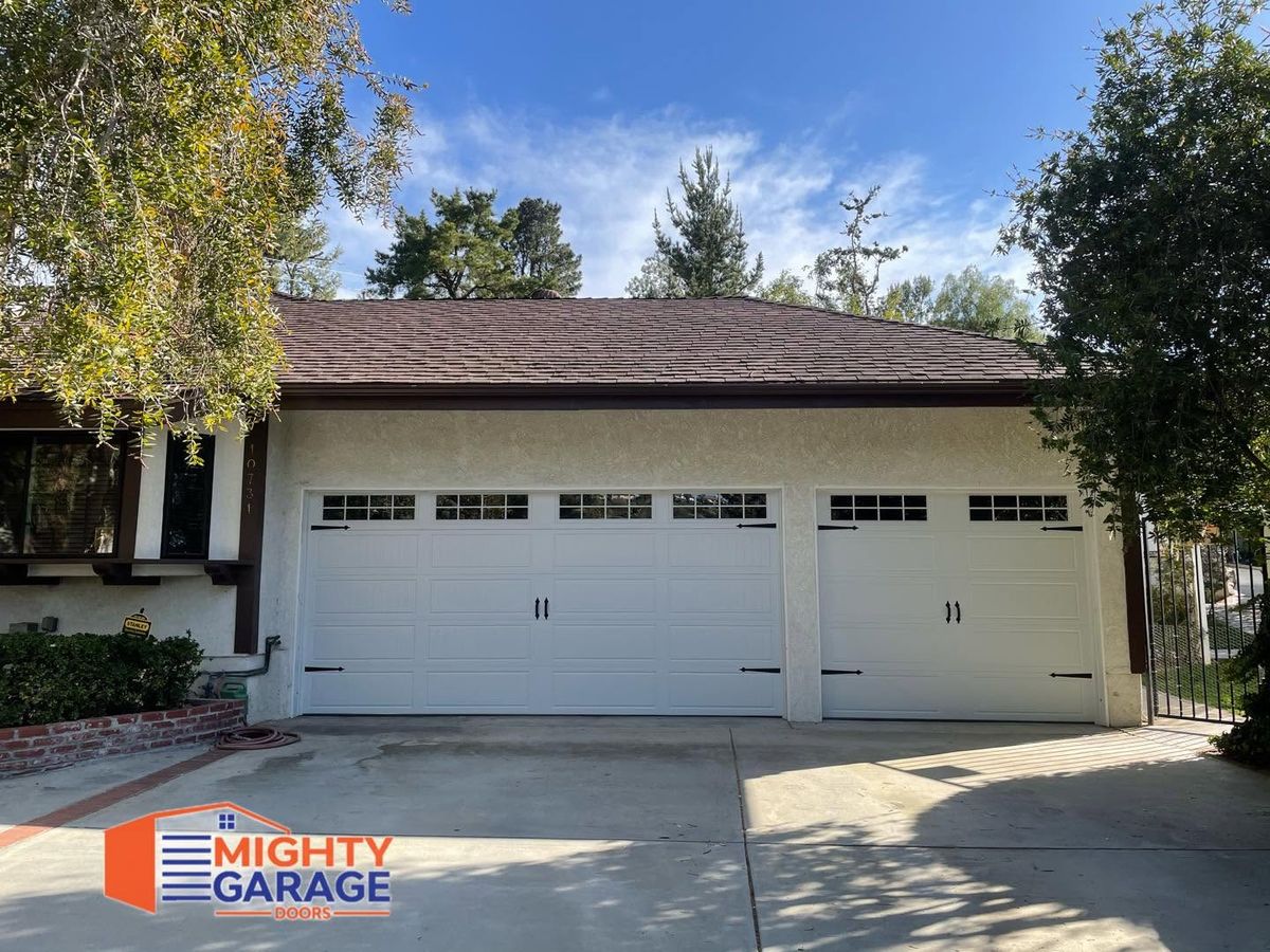 Cream double garage door and matching single door with window rows on a single-story ranch home in Orange