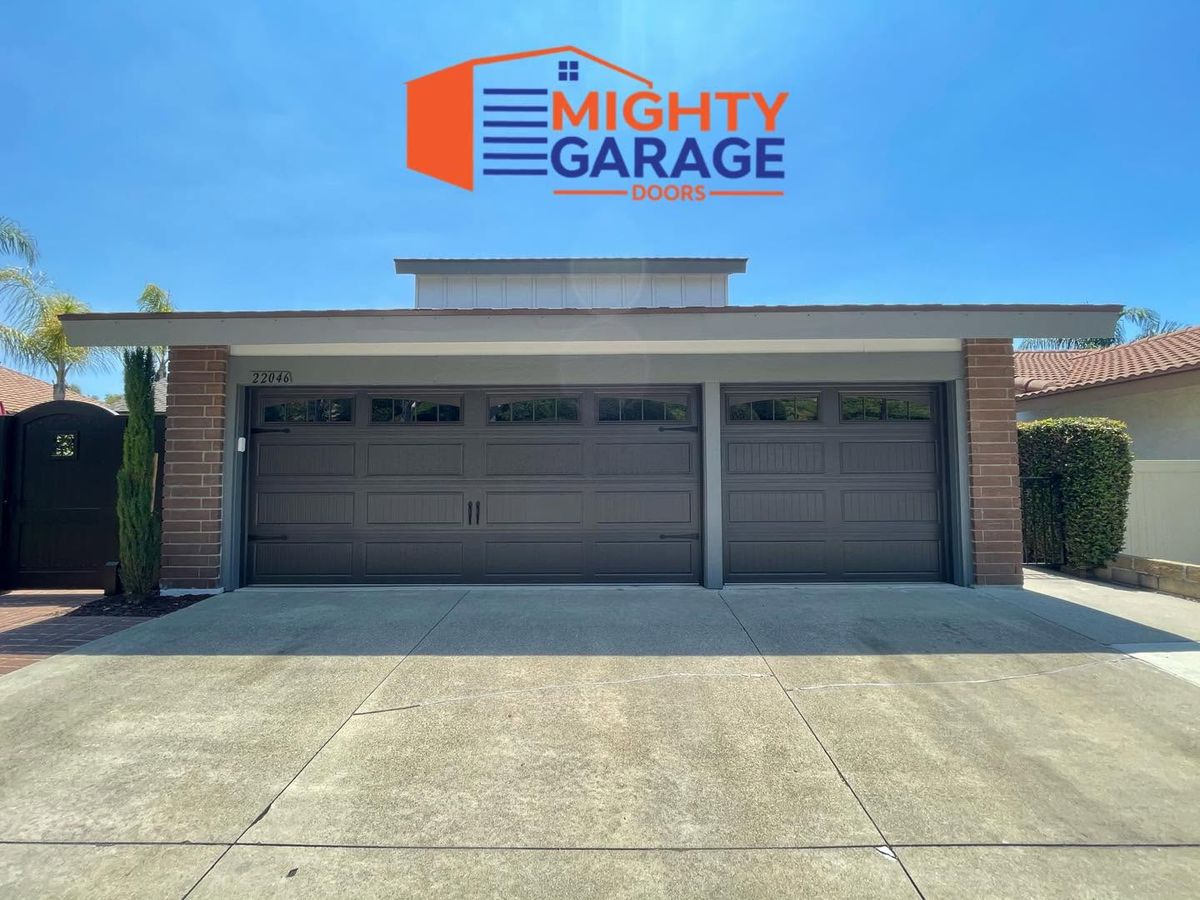 Two dark brown single garage doors side by side on a single-story brick-fronted home